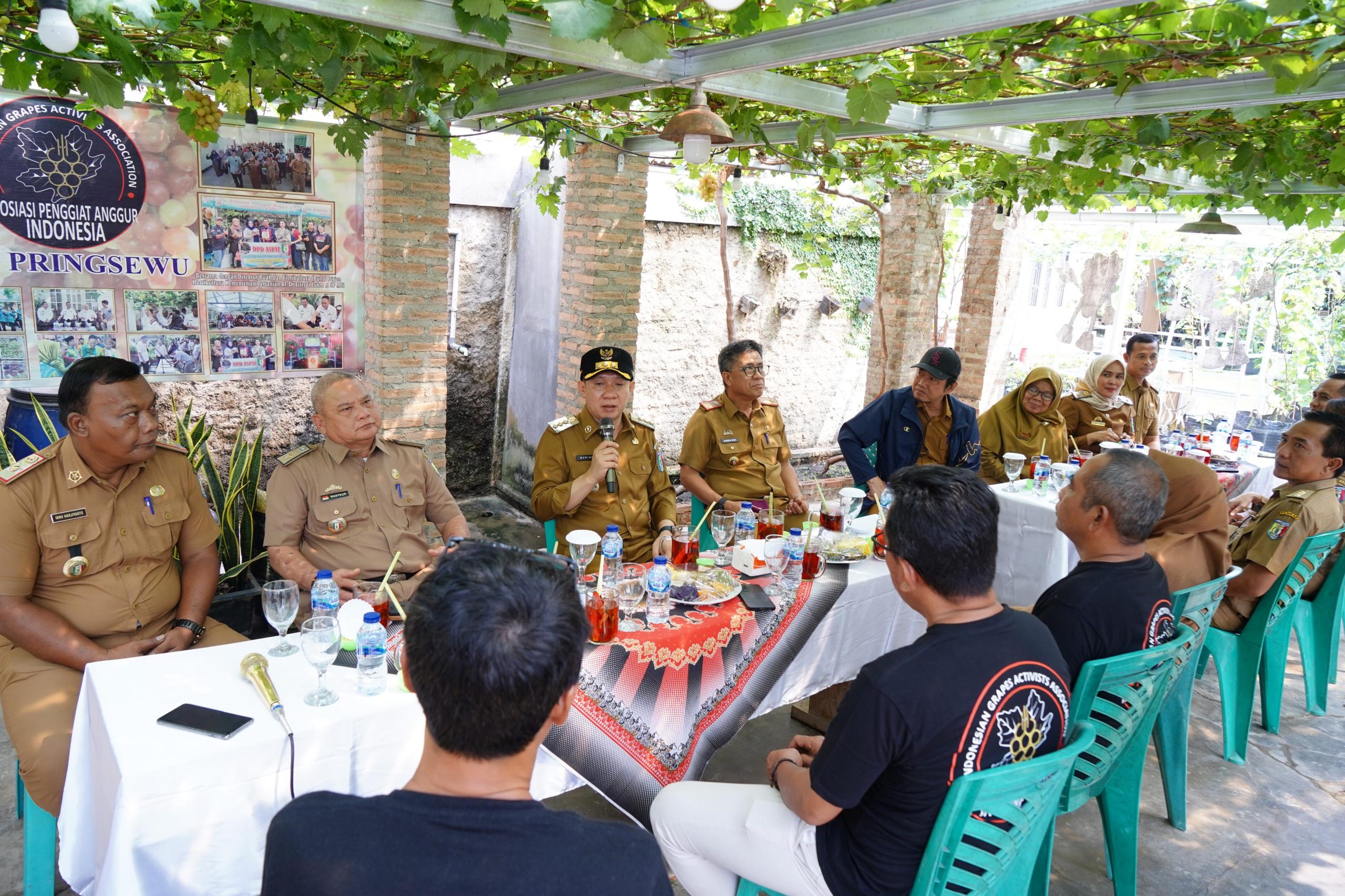 instruksi.co.id, Pringsewu - Pj. Bupati Pringsewu Dr. Marindo Kurniawan, S.T., M.M., melakukan kunjungan kerja ke komunitas Asosiasi Penggiat Anggur Indonesia (ASPAI) DPD Pringsewu yang berada di Pekon Ambarawa Kecamatan Ambarawa, Selasa (30/07/20024). Kunjungan ini merupakan bagian dari upaya pemerintah daerah untuk mendukung dan memajukan sektor pertanian, khususnya budidaya anggur yang tengah berkembang pesat di wilayah tersebut. Kunjungan ini didampingi oleh Asisten dan jajaran kepala OPD bertujuan untuk mengevaluasi perkembangan serta memberikan dukungan terhadap budidaya anggur yang dikelola oleh penggiat tersebut. Dalam kesempatan tersebut, Dr. Marindo Kurniawan meninjau langsung area budidaya dan pengembangan tanaman anggur yang ada di Pekon Ambarawa Kecamatan Ambarawa. Beliau berdialog dengan para penggiat anggur serta masyarakat setempat, dengan tujuan untuk memberikan motivasi dan dukungan. Pj. Bupati mengungkapkan harapannya agar kunjungan ini dapat menjadi momentum bagi kemajuan budidaya anggur di Kabupaten Pringsewu. Dalam kunjungannya, Dr. Marindo Kurniawan disambut oleh para petani anggur dan kelompok penggiat budidaya yang aktif di Kecamatan Ambarawa. Beliau mengungkapkan kekagumannya atas dedikasi dan usaha yang telah dilakukan oleh para petani dalam mengembangkan usaha budidaya anggur yang telah menjadi salah satu komoditas unggulan daerah. Dr. Marindo Kurniawan menyatakan pentingnya menjadikan tanaman anggur sebagai salah satu komoditas unggulan di Pringsewu dan mendorong para pelaku usaha untuk terus berkarya serta berinovasi dalam mengembangkan produk-produk berbasis anggur. Dengan dukungan dan semangat yang tinggi, diharapkan budidaya anggur dapat memberikan kontribusi signifikan terhadap perekonomian daerah dan kesejahteraan masyarakat. Tanaman anggur ini memiliki potensi yang sangat menjanjikan dan dapat berkontribusi signifikan terhadap perekonomian lokal. Selama kunjungan, beliau melakukan dialog langsung dengan petani, mendengarkan tantangan yang mereka hadapi, serta memberikan masukan terkait pemanfaatan teknologi terbaru dalam budidaya anggur. “Pengembangan budidaya anggur di sini menunjukkan komitmen dan semangat yang luar biasa dari para petani. Kami dari pemerintah daerah akan terus mendukung dengan berbagai inisiatif untuk meningkatkan kualitas dan kuantitas produksi anggur, termasuk melalui pelatihan, teknologi, dan akses pasar. Kami berharap kehadiran Pemerintah Daerah dapat membantu membantu para petani dalam meningkatkan produktivitas dan kualitas hasil panen mereka, sehingga anggur dari Kecamatan Ambarawa dapat dikenal lebih luas dan berdaya saing tinggi ” ujar Dr. Marindo Kurniawan. Penjabat Bupati juga menyampaikan pentingnya inovasi dan kerja sama antara petani, pemerintah, dan sektor swasta dalam memperkuat industri pertanian lokal. Kunjungan ini diharapkan dapat menjadi momentum bagi pengembangan lebih lanjut sektor pertanian di Kecamatan Ambarawa, serta meningkatkan kesejahteraan para petani anggur di wilayah tersebut.(hikmah/hmskab)