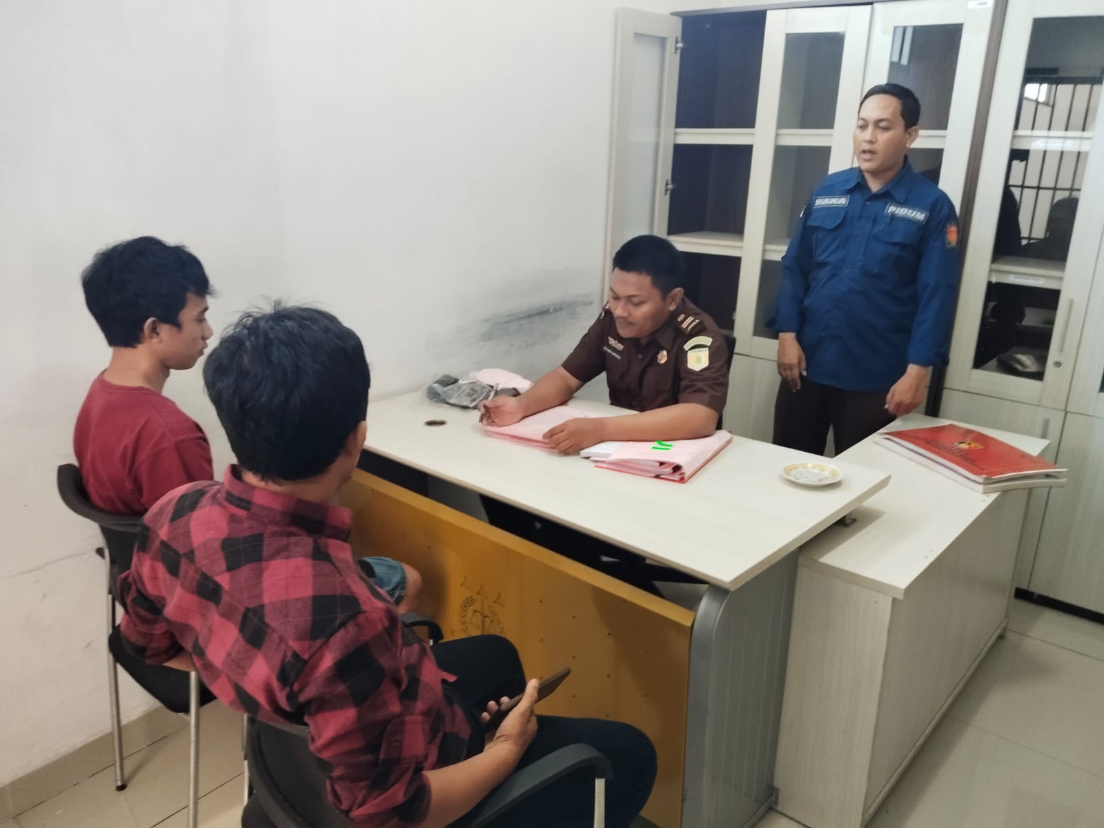 instruksi.co.id, Pringsewu - Penyidik Unit Reskrim Polsek Gadingrejo Polres Pringsewu resmi melimpahkan tersangka dan barang bukti dalam kasus tindak pidana kepemilikan senjata api rakitan ke Kejaksaan Negeri Pringsewu Pada Senin (28/7/2024) siang. Tersangka bernama Rizal Efendi (27), warga Desa Banjar Agung, Kecamatan Banjar Agung, Kabupaten Tulang Bawang, kini diserahkan kepada Jaksa Penuntut Umum untuk menjalani proses peradilan selanjutnya. Kapolsek Gadingrejo, AKP Hasbulloh, mengungkapkan bahwa pelimpahan ini dilakukan setelah menerima surat dari Kepala Kejaksaan Negeri Pringsewu yang menyatakan bahwa berkas perkara penyidikan atas nama tersangka Rizal Efendi sudah lengkap atau P-21. "Pelimpahan ini menindaklanjuti surat Kepala Kejaksaan Negeri Pringsewu yang menyatakan bahwa berkas perkara penyidikan atas nama tersangka Rizal Efendi sudah lengkap atau P-21," ujar AKP Hasbulloh pada Senin siang. Tersangka Rizal Efendi sebelumnya ditangkap polisi pada Selasa, 2 Mei 2024, sekitar pukul 08.30 WIB, di depan ruko di Dusun Wonokriyo, Pekon Wonodadi, Gadingrejo, Pringsewu. Sebelum penangkapan, Rizal dilaporkan oleh warga karena mondar-mandir mencurigakan di sekitar kampus Universitas Aisyah Pringsewu, seolah akan melakukan tindakan kriminal. Polisi yang menerima informasi tersebut segera menuju tempat kejadian perkara (TKP) dan menemukan Rizal yang terlihat panik. Setelah diperiksa, Rizal kedapatan membawa senjata api rakitan jenis pistol dengan empat butir amunisi aktif dan satu selongsong peluru yang disimpan dalam tas selempang yang dibawanya. "Sehubungan dengan kepemilikan senjata api ilegal ini, tersangka disangkakan melanggar pasal 1 ayat (1) UU Darurat Nomor 12 Tahun 1951 dengan ancaman hukuman 12 tahun penjara," tandas AKP Hasbulloh.(hikmah/hmspol)