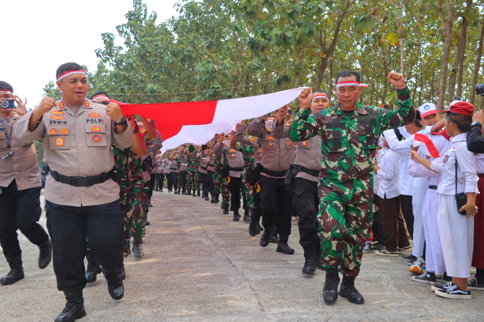 instruksi.co.id, Bandar Lampung – Ratusan personel gabungan Polresta Bandar Lampung dan Kodim 0410 Kota Bandar Lampung melakukan Kirab bendera merah putih digelar untuk menyambut Hari Kemerdekaan Republik Indonesia yang ke-79 di Bandar Lampung, pada Sabtu (10/8/2024). Bendera merah putih sepanjang 79 meter dibawa personel TNI – Polri keatas sebuah bukit di wilayah Sukabumi, Kota Bandar Lampung. Dalam pelaksanaannya kirab berlangsung meriah dengan melibatkan 200 personel gabungan dari kedua instansi. "Kegiatan ini merupakan simbol semangat kebangsaan kita dalam memperingati kemerdekaan Indonesia yang ke-79 tahun. Selain itu, ini juga menunjukkan sinergitas dan kekompakan dalam menjaga keutuhan NKRI dan keamanan di wilayah Bandar Lampung," kata Kapolresta Bandar Lampung, Kombes Pol Abdul Waras, S.I.K. Lebih lanjut disampaikan Abdul Waras mengatakan bahwa, kegiatan ini tidak hanya melibatkan aparat keamanan, acara ini juga mengajak siswa-siswi sekolah dasar di wilayah setempat untuk turut serta. "Kami ingin menanamkan rasa kebangsaan kepada adik-adik sebagai generasi penerus bangsa, sehingga mereka bisa menghargai dan memahami arti penting kemerdekaan," tambahnya. Selain itu, bendera sepanjang 79 meter ini juga memiliki makna simbolis, di mana panjang bendera yang digunakan sesuai dengan usia kemerdekaan Indonesia. Kegiatan ini tidak hanya bertujuan untuk membangkitkan semangat kebangsaan, tetapi juga untuk mempromosikan pariwisata di wilayah Bandar Lampung agar lebih dikenal oleh masyarakat luas. Kolonel Arh Tan Kurniawan, Komandan Kodim (Dandim) 0410/Kota Bandar Lampung juga menyampaikan pesan penting dalam kegiatan ini. "Kami bersama Polresta menginisiasi pengibaran bendera ini untuk memotivasi masyarakat Kota Bandar Lampung dalam menumbuhkan semangat kebangsaan. Harapannya, generasi muda dapat mengisi kemerdekaan dengan inovasi dan pembangunan yang lebih baik," jelas Dandim Dandim juga menuturkan, kegiatan ini menjadi momentum penting bagi masyarakat Bandar Lampung untuk mengenang kembali perjuangan para pahlawan yang telah berkorban demi kemerdekaan Indonesia. "Mari bersama-sama kita bangun NKRI dengan semangat dan rasa cinta tanah air yang tinggi," pungkas Dandim. (Suhartono/rls)